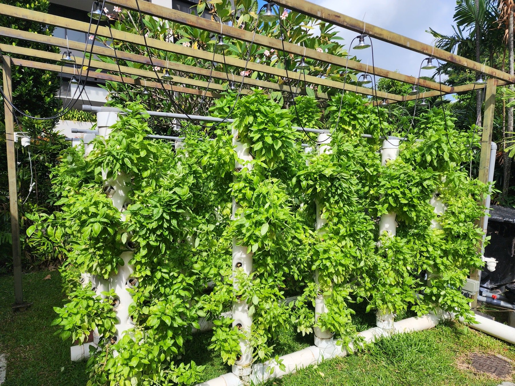 Vertical Aquaponics Tower at Owl Farm, densely covered in lush greenery