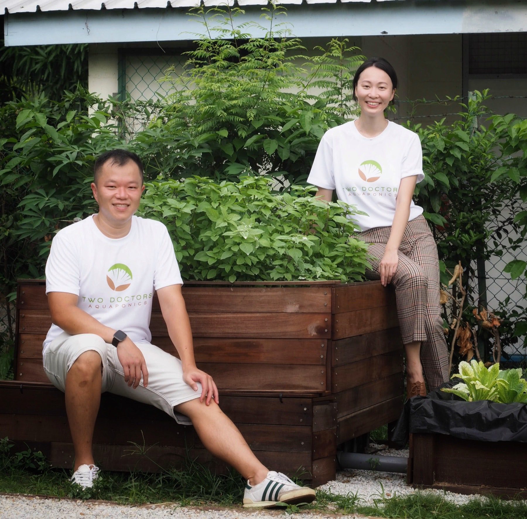 A custom-built raised aquaponics growing bed installed at a home, surrounded by lush greenery